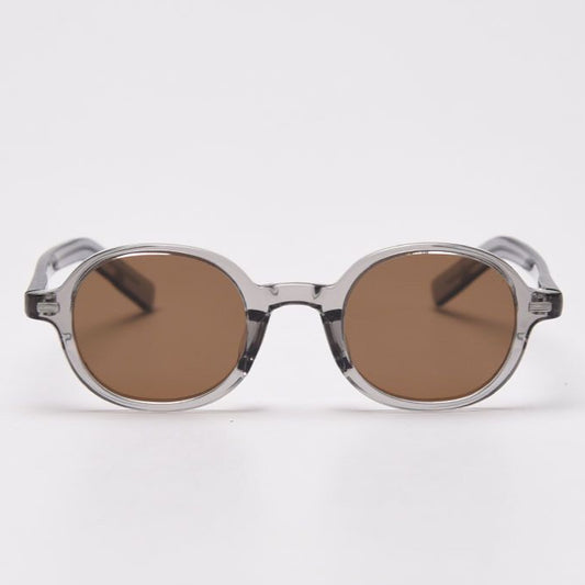 Round sunglasses with transparent frame and brown lenses on a white background