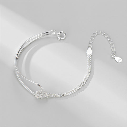 Silver bracelet on a light gray background