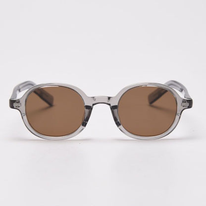 Round sunglasses with transparent frame and brown lenses on a white background
